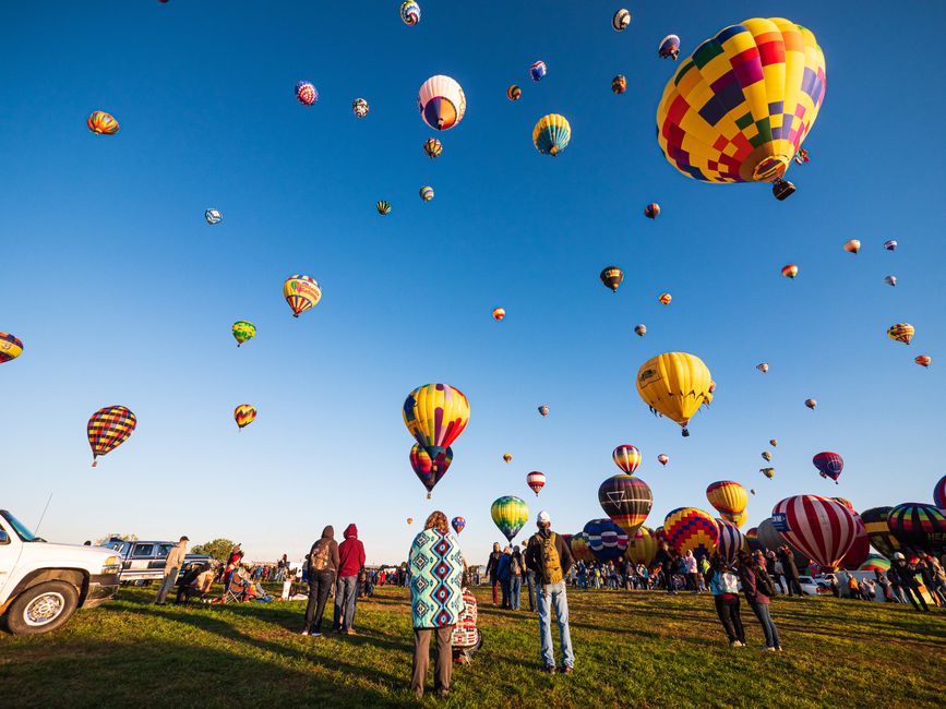 Colorful hot air balloons fill the sky during a lively festival in Albuquerque, New Mexico.