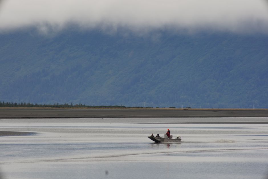 Two people boating on calm waters with mountains in the background, Anchorage, Alaska.