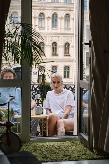A couple enjoys a peaceful moment on a stylish urban balcony with a scenic backdrop.