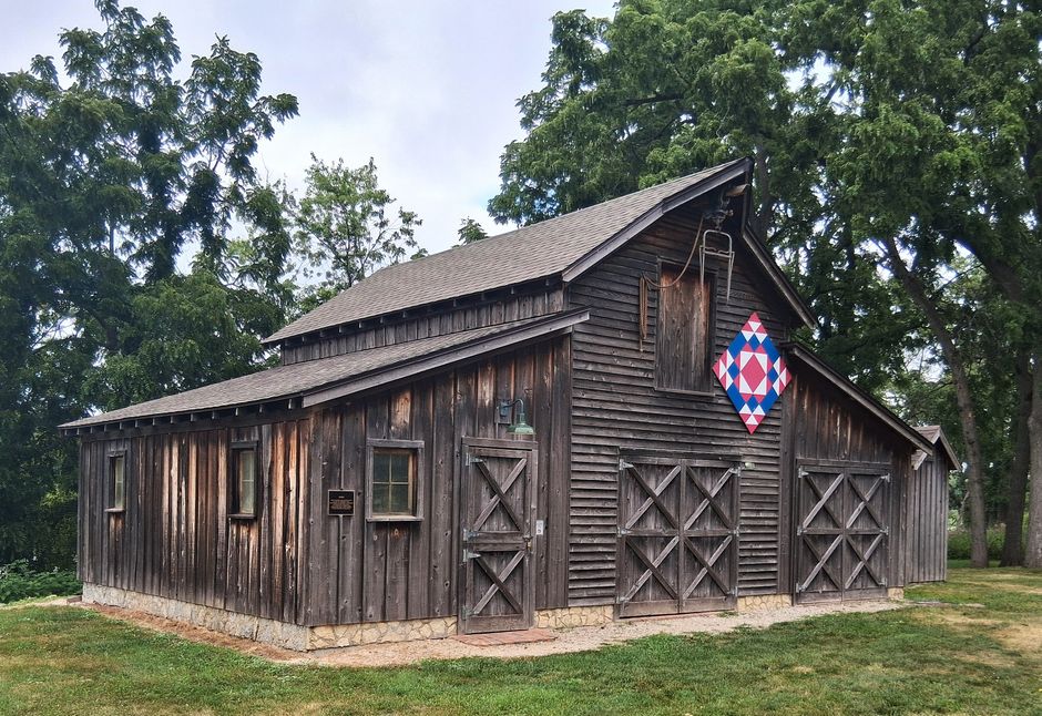 Charming wooden barn with a colorful quilted pattern on a sunny day in Beloit, Wisconsin.
