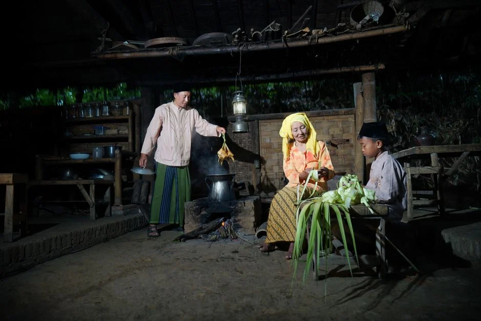 Family preparing traditional meal in a rustic kitchen setting, depicting cultural heritage and togetherness.