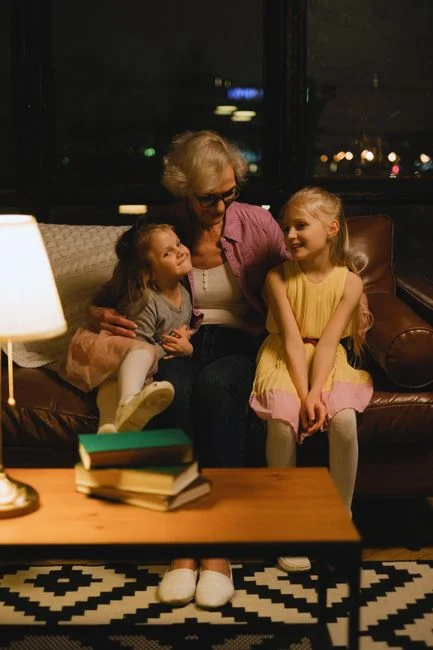 Grandmother bonding with granddaughters in cozy living room setting.