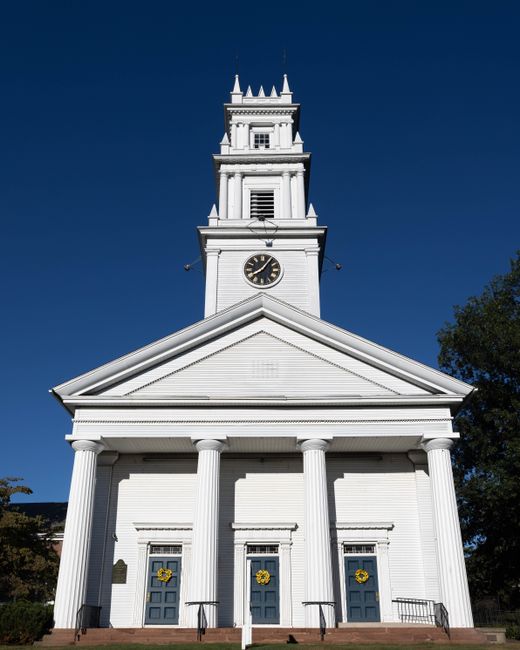 Elegant white church with clock tower on a sunny day in Bristol, Connecticut.