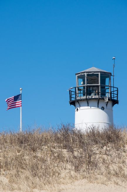 A picturesque view of Chatham Lighthouse in Massachusetts against a clear blue sky.