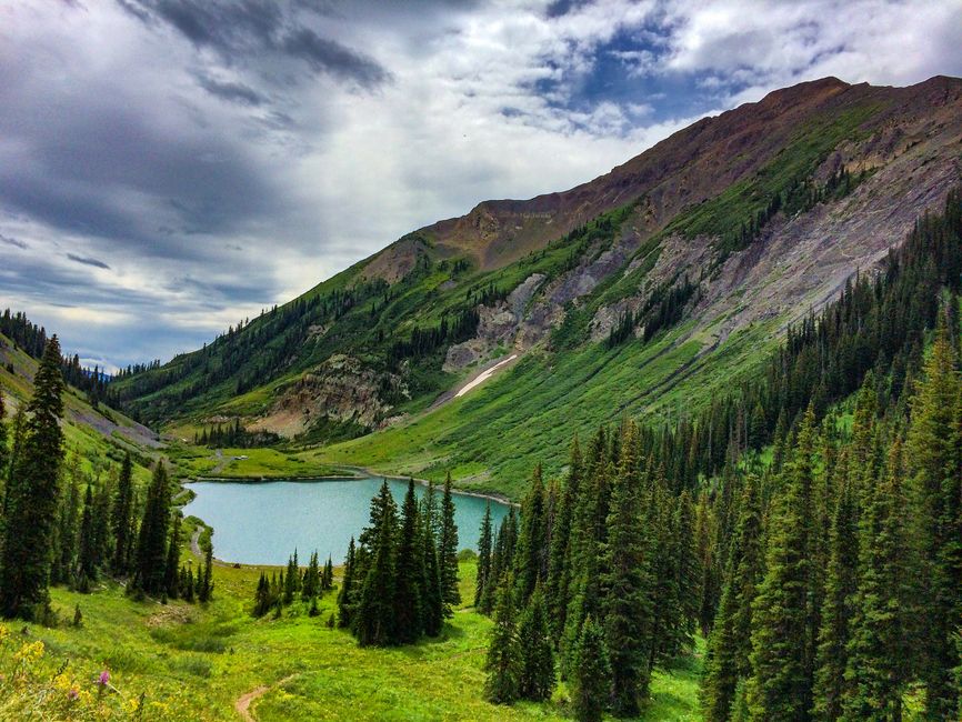 Breathtaking mountain landscape with lush greenery and a shimmering lake in Aspen, Colorado.