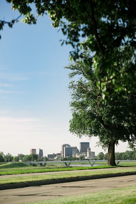A scenic view of Dayton's skyline framed by lush trees on a sunny day.