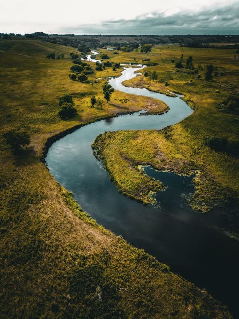 Scenic aerial shot of a winding river through lush countryside in Jamestown, North Dakota.