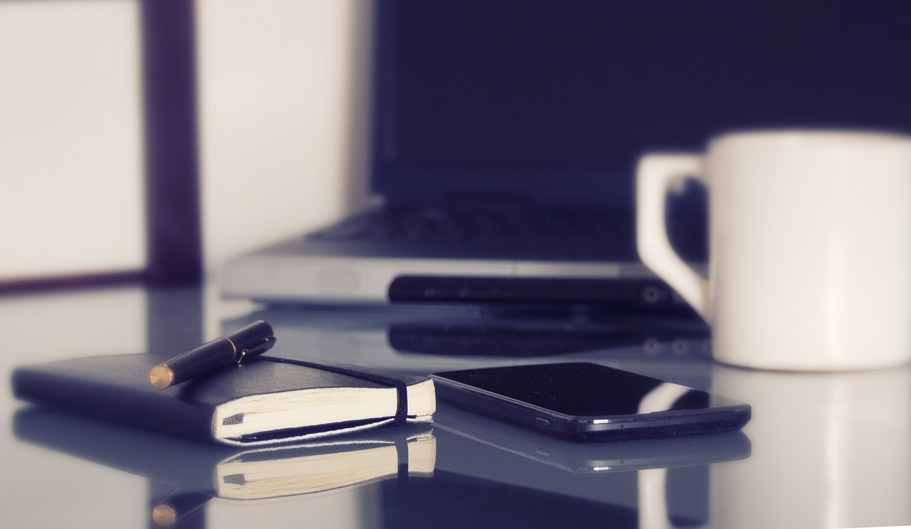 Computer, laptop, in a working environment, coffee, coffee cup, pen, notebook, desk, work, home offices, cellphone, organization, computer, computer, coffee cup, pen, desk, desk, work, work, work, wor
