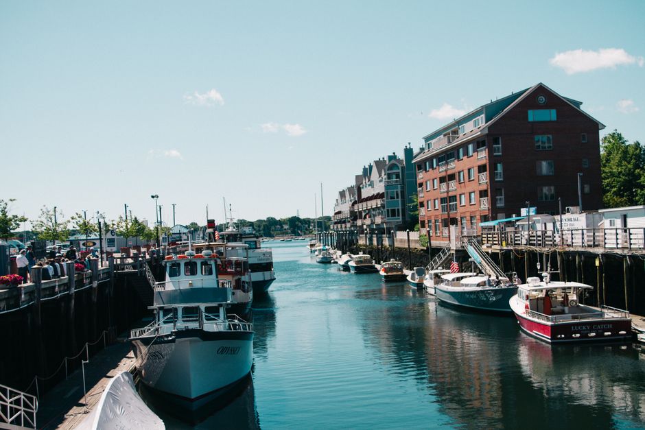 Scenic view of boats docked at a vibrant harbor beside brick buildings.