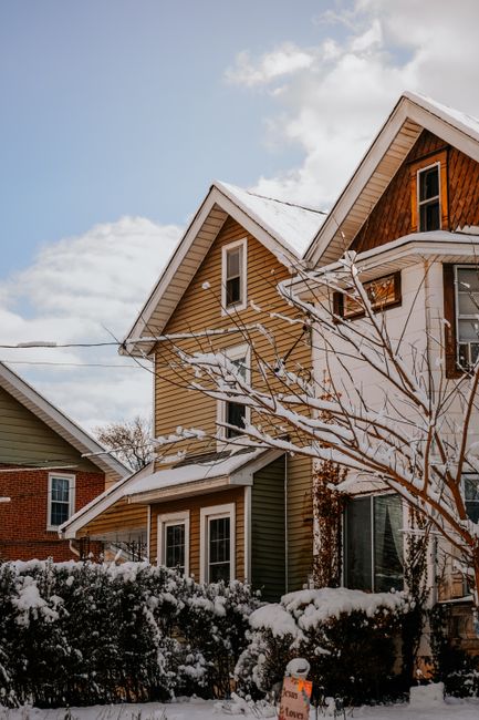 Picturesque suburban houses covered in snow on a sunny winter day.