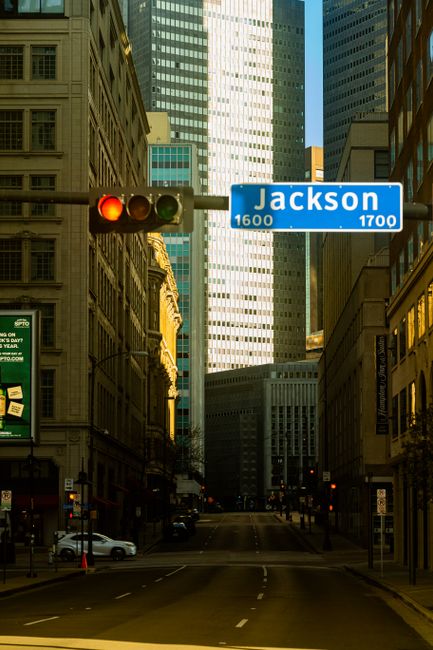 A downtown intersection with skyscrapers and a traffic light in a bustling cityscape.