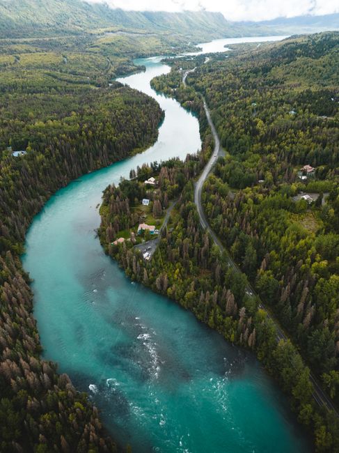 Scenic aerial view of the blue Kenai River winding through lush forests in Cooper Landing, Alaska.