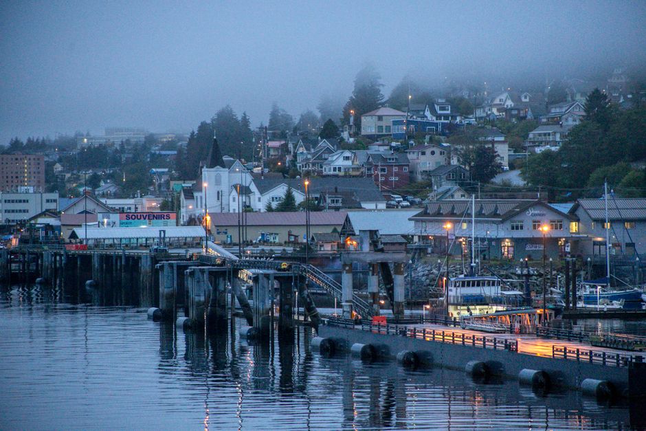 Scenic foggy harbor view of Ketchikan, Alaska, showcasing the coastal town's waterfront and reflections.