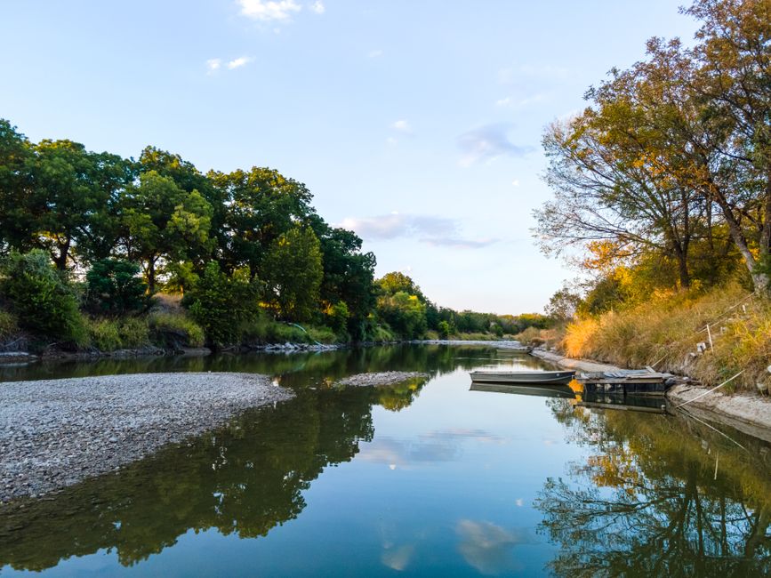 Serene scene of a tranquil lake and boat at sunset in Killeen, Texas, reflecting the beauty of nature.