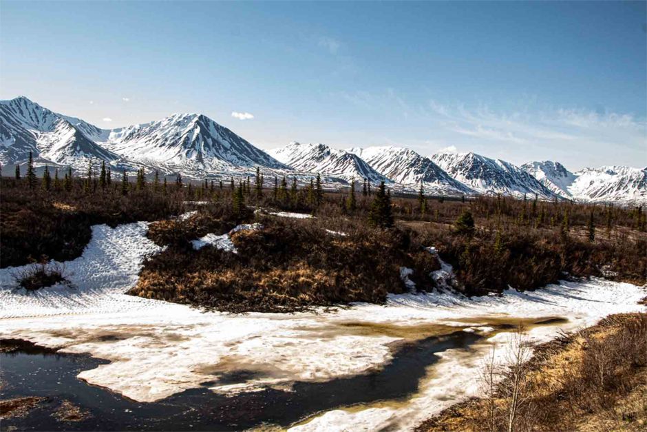 Snow-capped mountains and icy river with spring landscape in Alaska.
