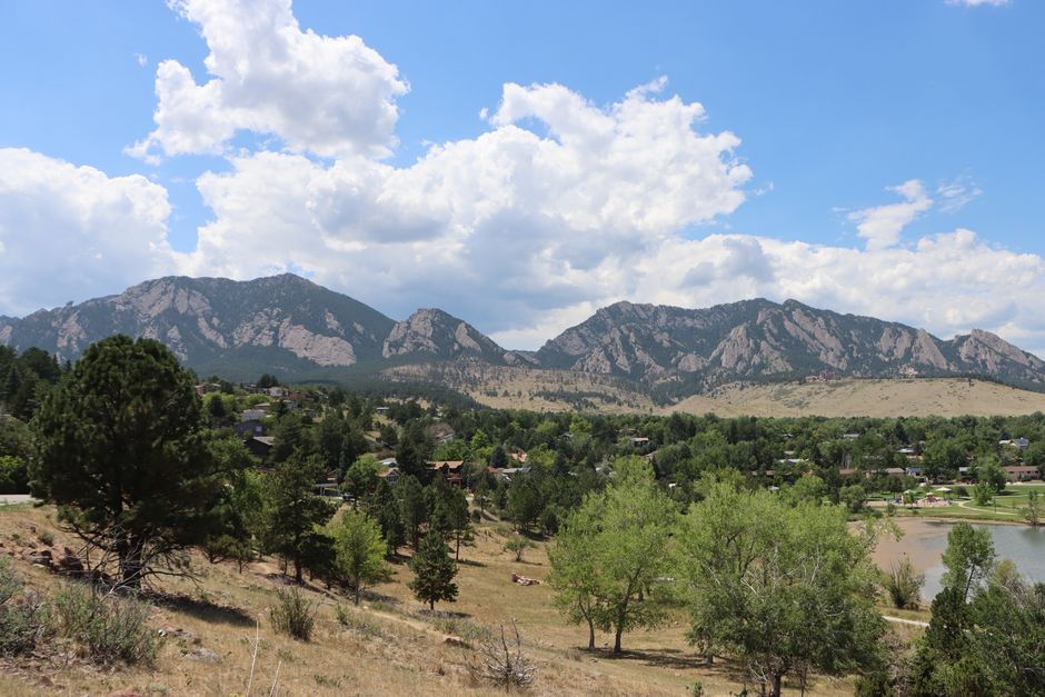 Scenic landscape of Boulder, Colorado with the Rocky Mountains under a blue sky.