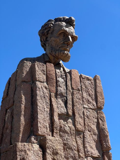 Stone bust of Abraham Lincoln set against a clear blue sky in Laramie, Wyoming.