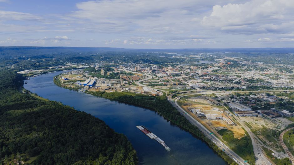 A stunning aerial view of Chattanooga showcasing the Tennessee River and urban landscape under a clear sky.