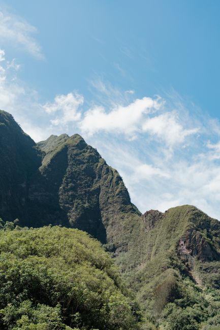 Breathtaking view of lush green mountains under a clear blue sky in Iao Valley, Maui, Hawaii.