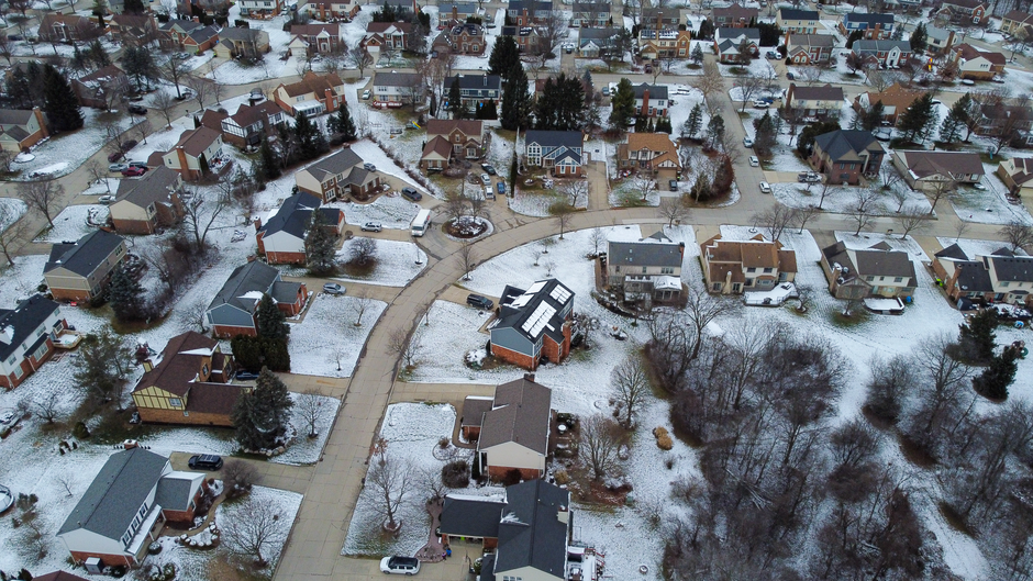 Aerial view of a snow-dusted suburban neighborhood in winter
