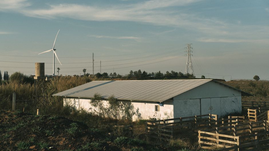 Scenic rural farm landscape with barn and wind turbine.