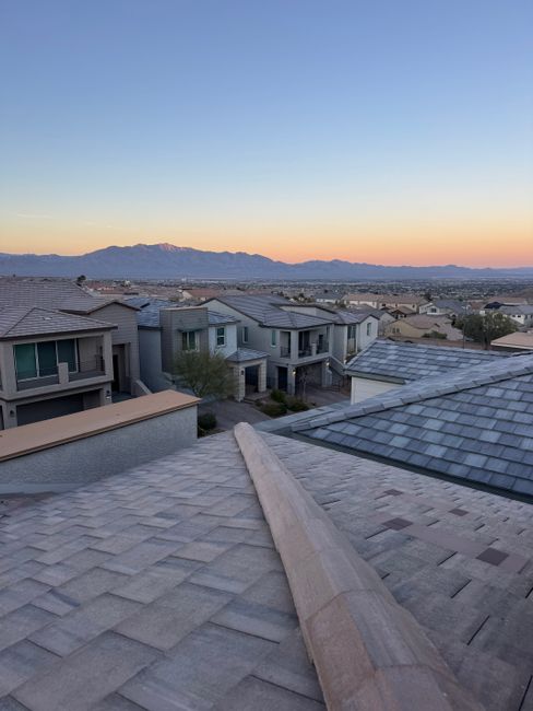 A serene view of suburban rooftops with a mountain backdrop at twilight in Las Vegas, NV.