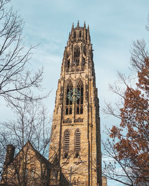 Iconic Harkness Tower surrounded by autumn trees at Yale University in New Haven, CT.