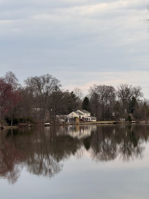 Charming lakeside house with autumn trees reflecting in tranquil water. Captured in New Jersey.