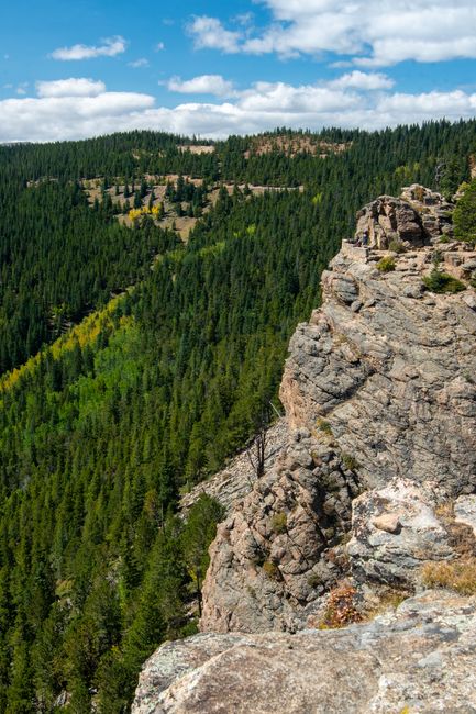 Majestic rocky cliffs and forested landscape in Colorado under a clear blue sky.