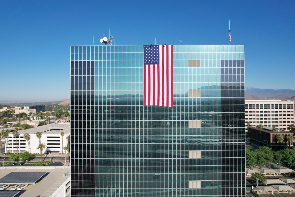 Aerial view of a glass skyscraper with an American flag in Riverside, California.