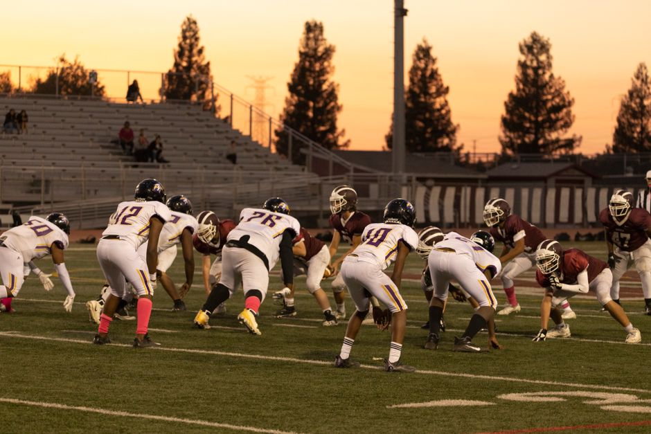 Intense American football game between two teams at sunset in Roseville, California.