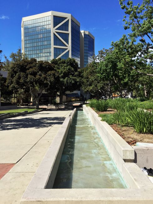 Contemporary glass building near a scenic urban park in Santa Ana, California.
