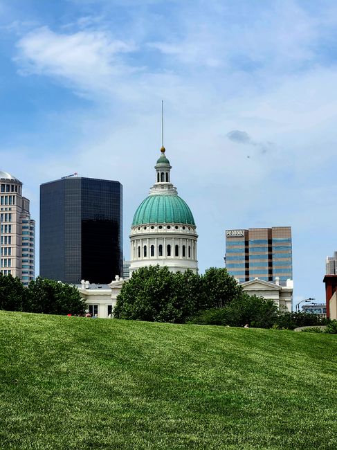 Historic St. Louis Old Courthouse with city skyline and lush green park.