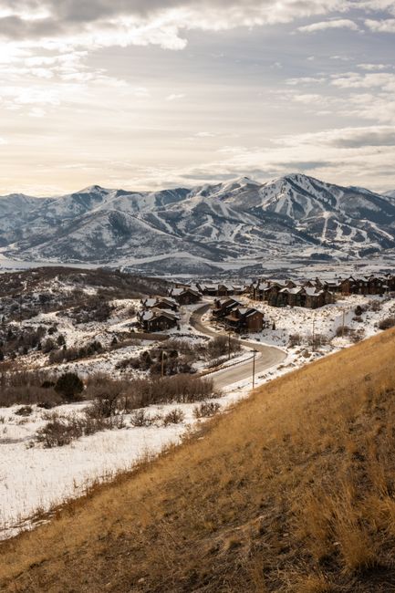 Scenic view of a snow-covered mountain landscape in Utah with rustic houses below.