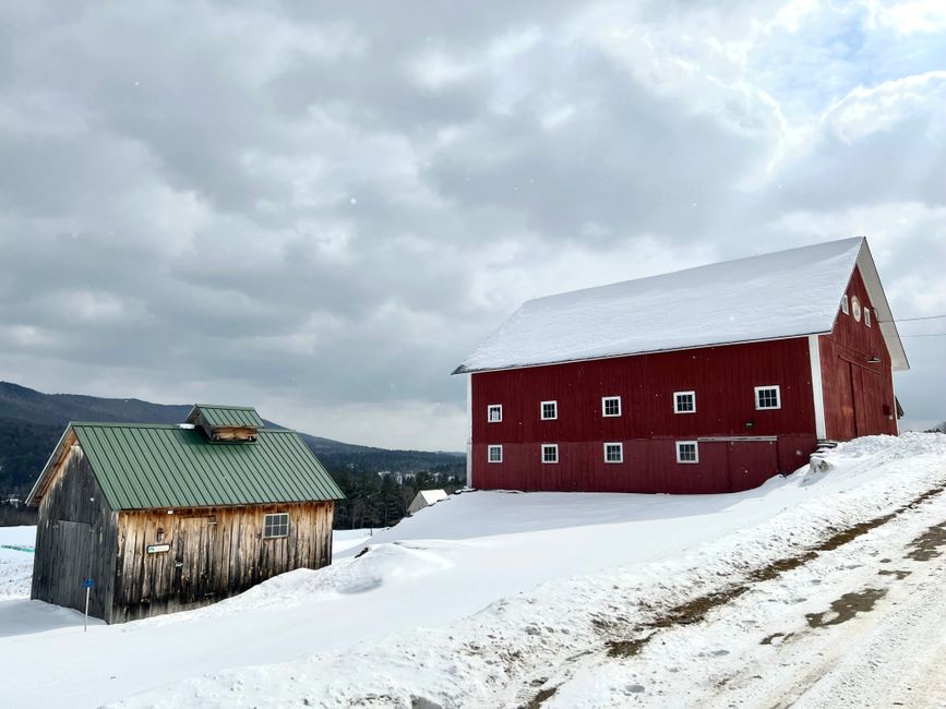 Captivating view of a red barn in a snowy Vermont landscape, capturing rural winter charm.