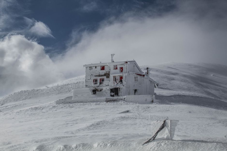 A remote house covered in snow on a serene winter day.
