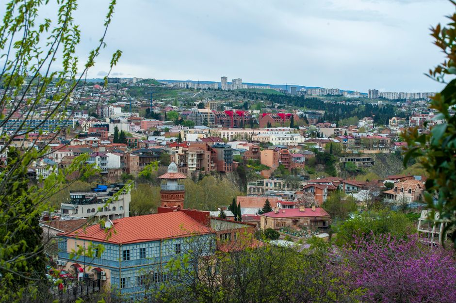 Explore the stunning urban landscape of Tbilisi, Georgia with lush greenery and traditional architecture.